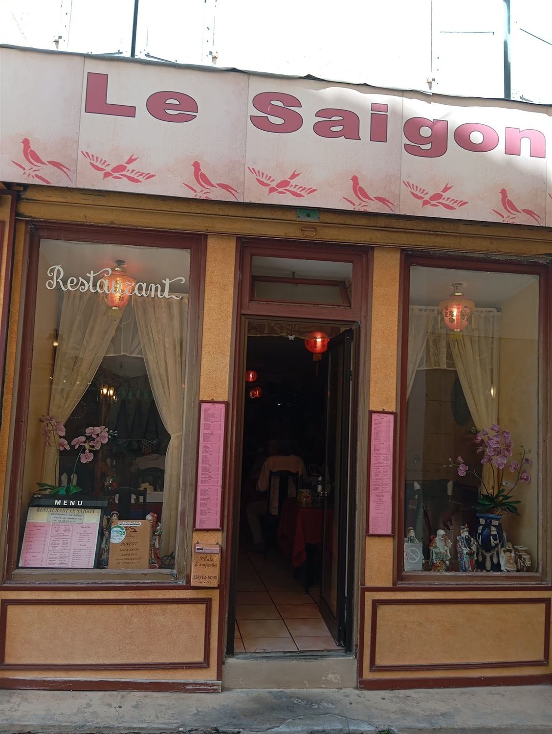 Façade du restaurant Le Saigon, enseigne rose et vitrines aux rideaux