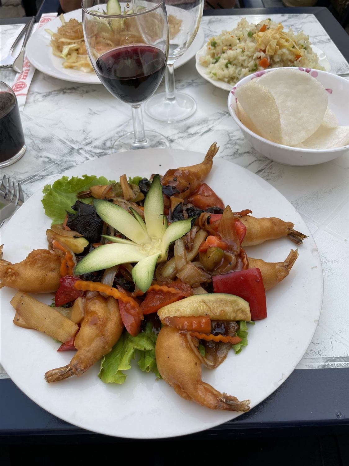 Cuisses de grenouilles sautées, fleur de concombre et verre de vin rouge