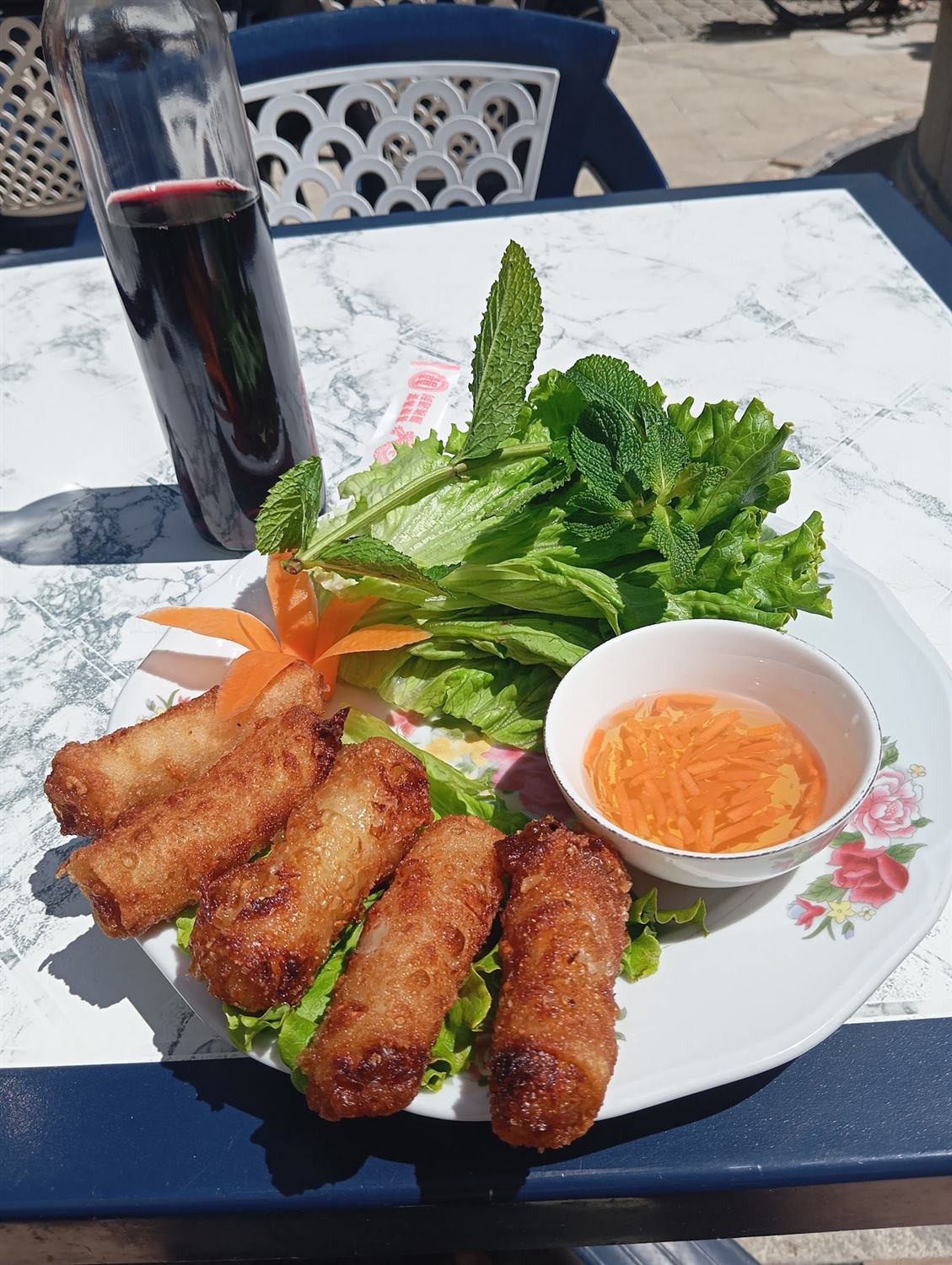 Nems croustillants servis avec salade, herbes fraîches et sauce