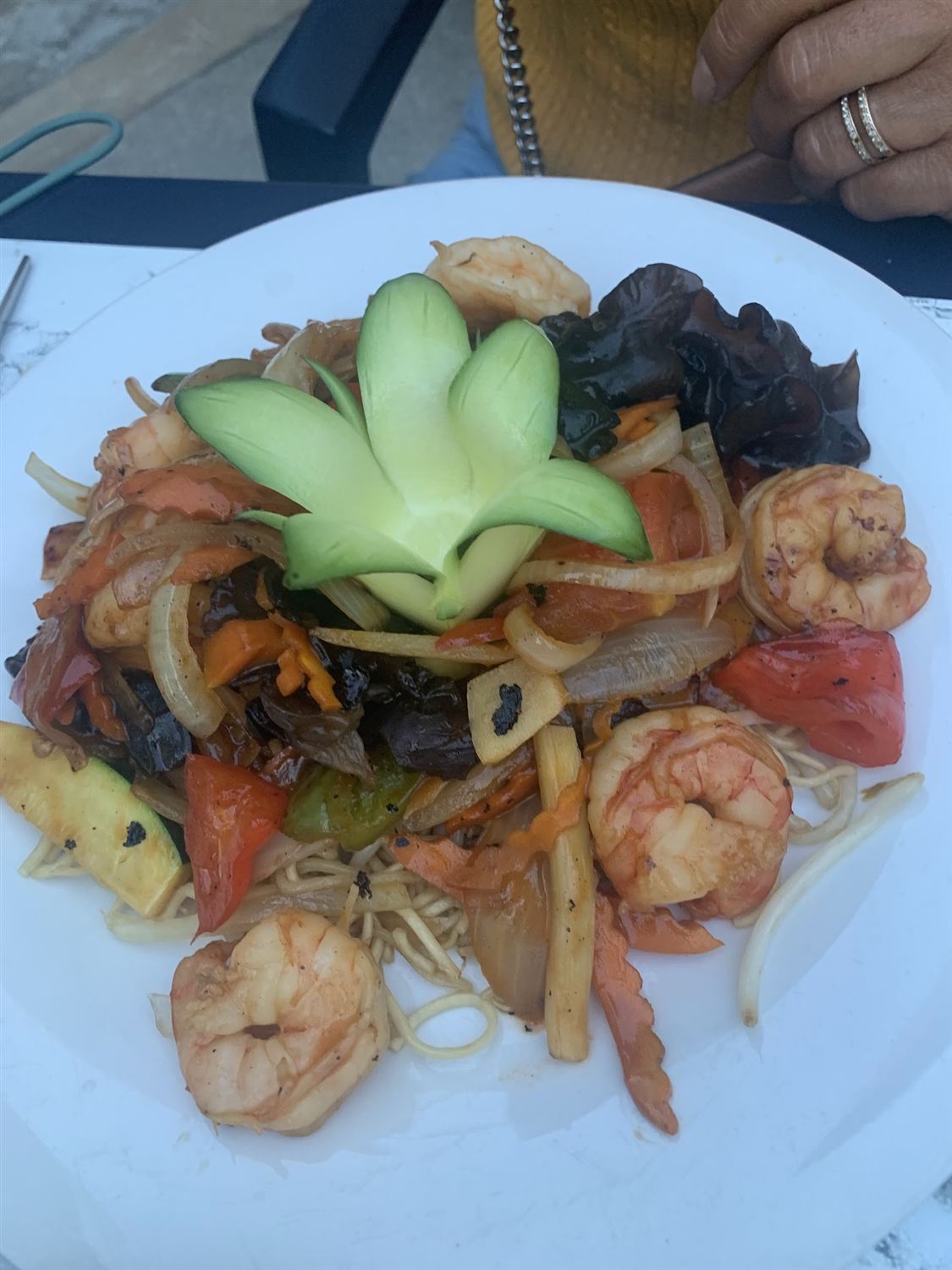 Nouilles sautées aux crevettes et champignons noirs, fleur de concombre au centre